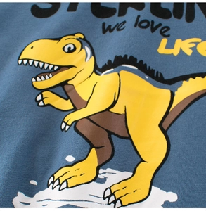 Detail of blue cotton kid's T-shirt with yellow cartoon dinosaur and typography print