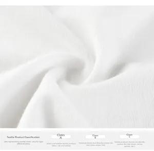 Close-up of white soft cotton fabric texture and textile safety standard labels