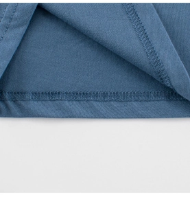 Detailed close-up of double-stitched hem on blue cotton knit toddler dinosaur t-shirt