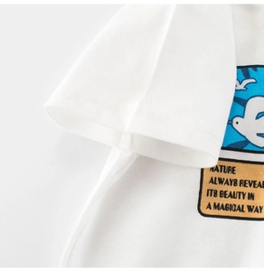 Close-up of white cotton boy's t-shirt showing neat sleeve stitching and sky illustration