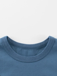 Close-up of blue crew neck cotton T-shirt neckline with ribbed stitching for kids