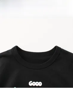 Détail d'un t-shirt noir à col rond avec col en maille côtelée et impression graphique Gooo
