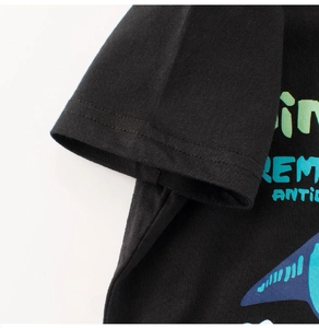 Détail d'un t-shirt enfant noir en coton avec couture double aux manches et motif de requin