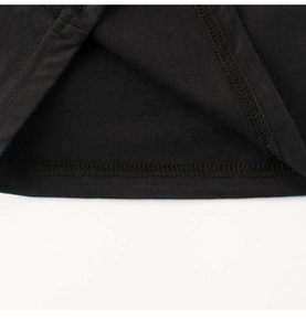 Détail de la couture double sur l'ourlet d'un t-shirt en coton noir pour enfants