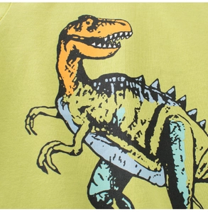 Détail d'un t-shirt enfant en coton vert avec impression de dinosaure orange