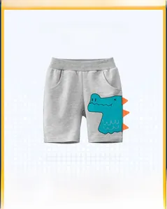 Detail of grey kids shorts with blue crocodile patch and orange 3D triangles