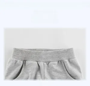 Close-up of elastic waistband and pocket detail on light gray cotton knit shorts