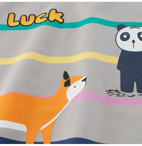 Détail d'un t-shirt gris avec renard, panda, texte Luck et rayures colorées