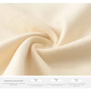 Macro detail of soft off-white cotton knit fabric texture with textile safety labels