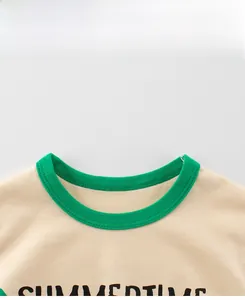 Close-up of kids beige cotton T-shirt featuring a contrast green ribbed crew neck