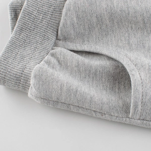 Close-up of grey cotton knit kids shorts showing ribbed elastic waistband and stitching