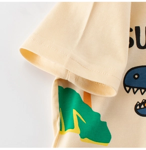 Close-up of cotton kids T-shirt fabric with dinosaur print and sleeve stitching