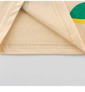 Detailed macro view of cotton t-shirt hem with cartoon dinosaur print and neat stitching