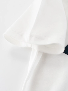 Detailed close-up of double-needle stitching on the cuff of a white cotton kids' T-shirt