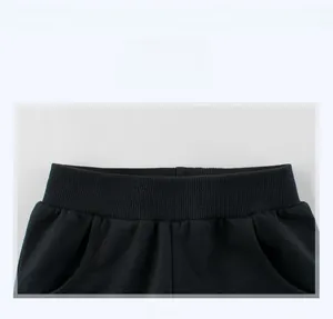 Detail view of the black elastic ribbed waistband on kids shorts with fine stitching