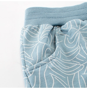 Detail of light blue boys' cotton knit shorts showing elastic waistband and side pockets