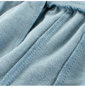 Macro view of light blue knitted french terry fabric with reinforced stitching detail
