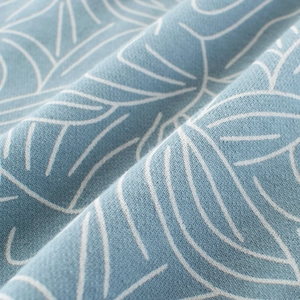 Detailed macro view of soft blue knitted fabric with white leaf pattern on summer shorts