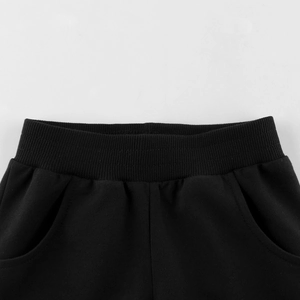 Front view of boys black cotton blend shorts with elastic ribbed waistband and side pockets
