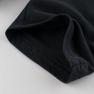 Close-up of high-quality black knit cotton fabric showing durable double-needle stitching