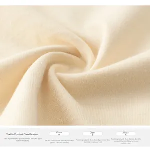 Detailansicht von weichem cremefarbenem Strickstoff und Sicherheitsstandards für Kinderbekleidung