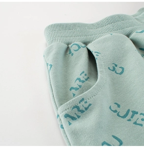 Détail du short garçon en coton vert menthe avec taille élastique et motif texte