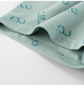 Vue détaillée de l'ourlet à double aiguille sur un short vert avec motif texte