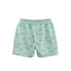 Gros plan du tissu en coton vert menthe et des motifs de lettres sur le short enfant