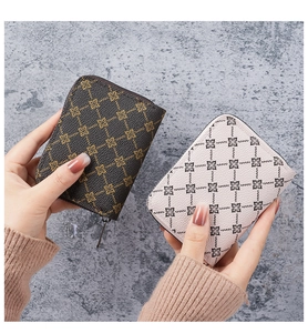 Close-up of compact faux leather card wallets with geometric patterns held by hand
