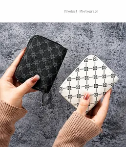 Close-up of black and white checkered card wallets with silver zippers in hands