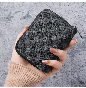 Close-up of black synthetic leather zipper wallet with geometric cross pattern