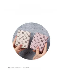 Close-up of mini zip card holders in beige and pink leather with monogram pattern