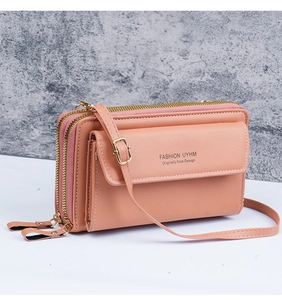 Detailed view of pink crossbody phone bag with double zippers and golden metal hardware
