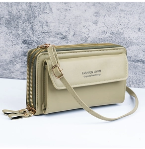 Detail view of the multi-layer cross-body bag with triple zipper and olive green contrast