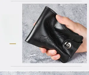 Close-up of flexible black leather wallet with anime skull motif and metal button clasp