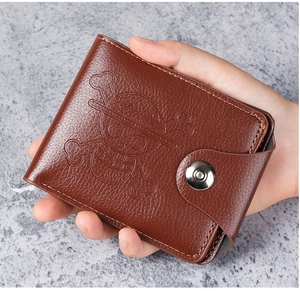 Detailed view of brown bifold leather wallet with skull embossed logo and snap closure