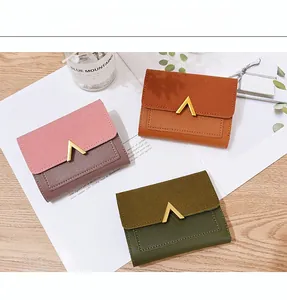 Detailed view of three vintage-style matte leather wallets with V-shaped metal buckles