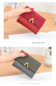 Close-up of vintage matte leather wallets with V-shaped metal accent and stitching