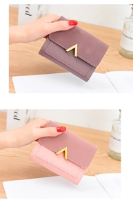 Detail of matte retro bi-fold wallets with metallic V-shaped buckle and stitching