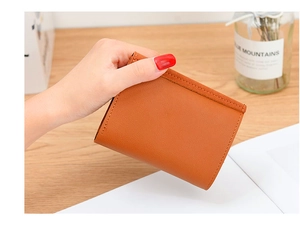 Detailed view of a vintage brown matte leather wallet featuring V-shape metal trim and neat stitching