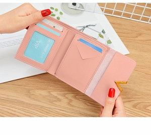 Macro view of pink faux leather wallet interior with card slots and a clear ID window