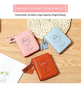 Detalle de carteras de cuero PU con relieve de gato, borlas y dijes de orejas de conejo