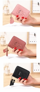 Detalle de mini carteras de gato con borlas de conejo en varios colores elegantes