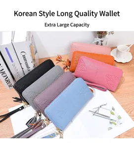 Detail of long PU leather wallets with leaf embossing, zip closure and tassel strap