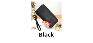 Detail of black long wallet with lychee texture, leaf embossing, and zipper wrist strap
