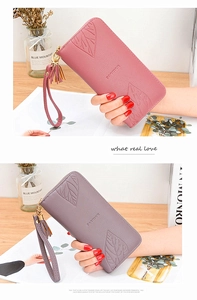 Detail of long leather wallets with maple leaf embossing and tassel wristlet strap