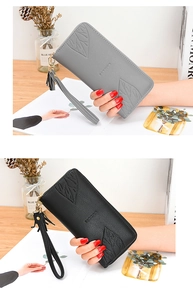 Close-up of maple leaf embossed texture and tassel on long zipper wallets for women