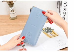 Close-up of sky blue long wallet featuring maple leaf embossing and fashion logo