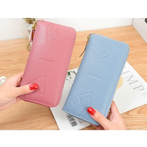 Detail of long zip wallets with leaf relief and textured faux leather finish
