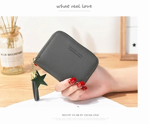 Detail of grey PU leather wallet with metallic zipper and star tassel ornament